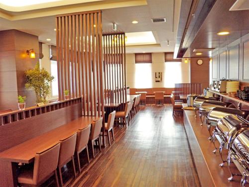 a dining room with a long table and chairs at Hotel Route-Inn Higashimuroran Ekimae in Muroran