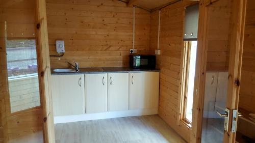 a kitchen with white cabinets and a sink in a room at The Cabin @Tenacre in Boston