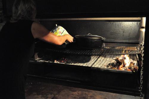 a woman is putting a pot in an oven at Obelix Guesthouse in Lüderitz