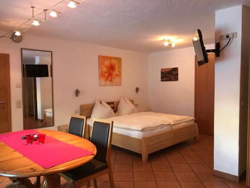 um quarto com uma cama e uma mesa com uma sala de jantar em Appartements Kröll em Saalbach-Hinterglemm