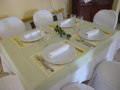 a table with white plates and wine glasses on it at Hotel "La Salute" in Monte Grimano Terme