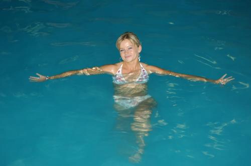 a woman is swimming in the water at Suvendes Apartments in Prato allo Stelvio