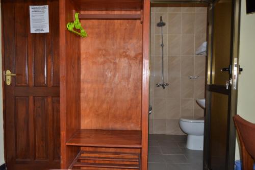 bagno con servizi igienici e porta in legno di Barcelona Lodge a Bagamoyo