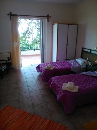 モネンバシアにあるMaviriaのベッドルーム1室(ベッド2台付)、バルコニーへのドアが備わります。