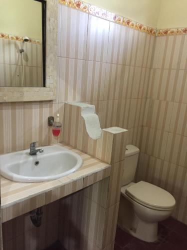 y baño con lavabo, aseo y espejo. en Batan Duren House en Ubud