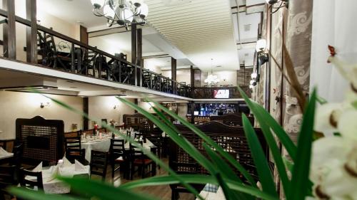 a dining room with tables and chairs and a staircase at Hamlet Hotel in Bacău
