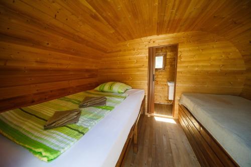 a bedroom with two beds in a wooden cabin at Tokaj Zlatá Putňa - Restaurant & Pension in Viničky
