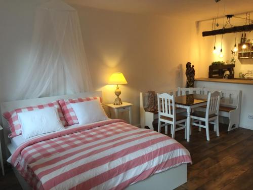 a bedroom with a bed and a table and chairs at Ferienwohnungen Neusiedl am See in Neusiedl am See