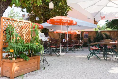a patio with tables and chairs and an umbrella at Gasthof Wastlwirt in Salzburg