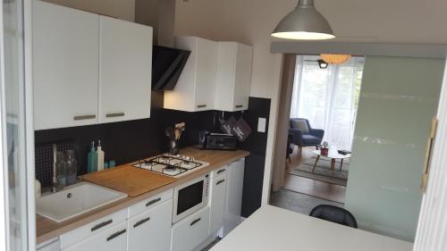 a kitchen with white cabinets and a sink at Paraire in Rodez