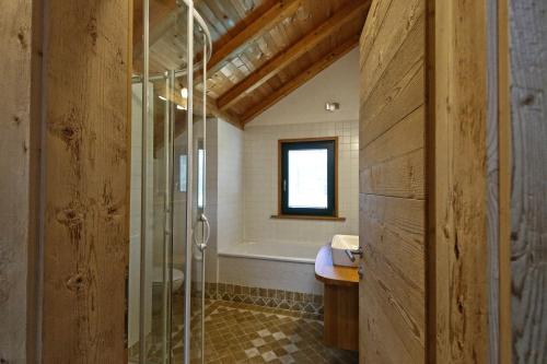 a bathroom with a glass shower and a sink at La Bercia Alpine Lodge & Spa in La Villa