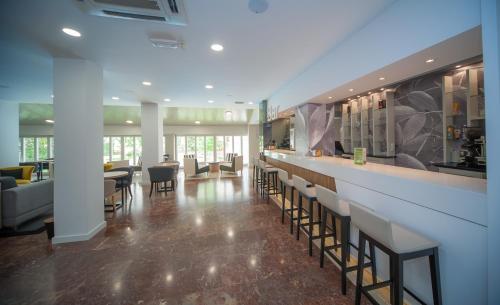 a lobby with a bar with chairs and tables at Gran Hotel de Jaca in Jaca