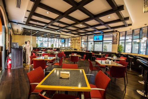 a restaurant with tables and chairs and a man standing in the middle at Welcome Hotel Apartments 1 in Dubai