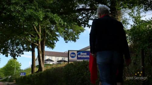 an older man standing in front of a best western sign at Best Western Hotel Slenaken in Slenaken