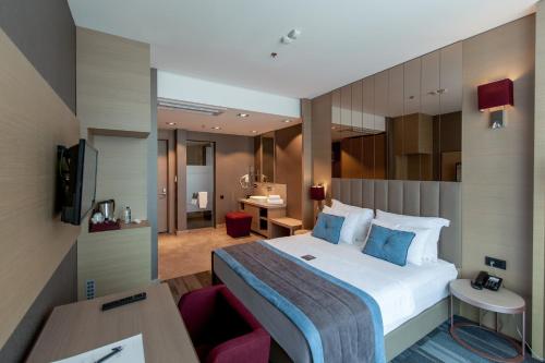 a hotel room with a bed and a desk at Vista Hotel in Mezitli