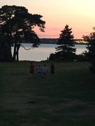 a group of people walking in a field at sunset at Bell Tent Glamping at Royal Victoria Country Park in Southampton
