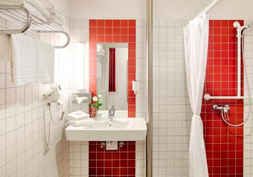 ein Badezimmer mit einem weißen Waschbecken und roten Fliesen in der Unterkunft CFK - Spiesen-Elversberg in Spiesen-Elversberg