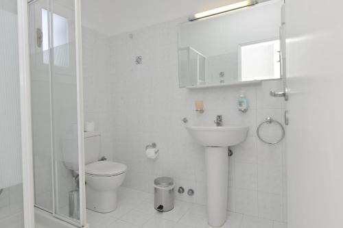 La salle de bains blanche est pourvue de toilettes et d'un lavabo. dans l'établissement Janos Studios and Apartments, à Náoussa