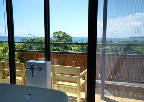 a room with a balcony with a view of the ocean at The Red Hotel in Nanwan