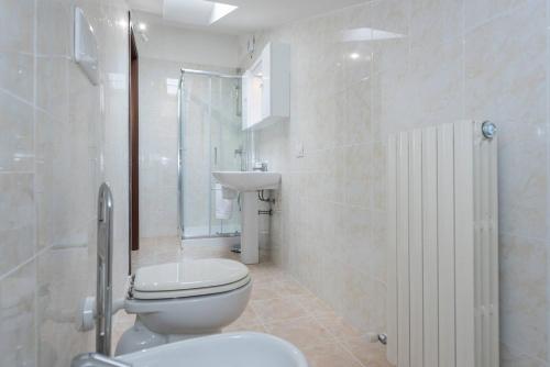 een badkamer met een toilet, een wastafel en een douche bij Dimora Ronchi in Ronchi