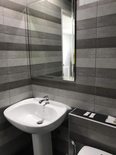 a bathroom with a sink and a mirror and a toilet at Asia's Beach Apartments in Sattahip
