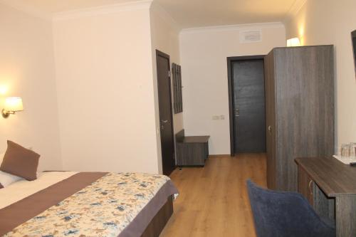 a hotel room with a bed and a chair in it at Non-stop hotel in Boryspilʼ