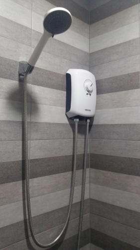 a shower with a blow dryer on a wall at Asia's Beach Apartments in Sattahip