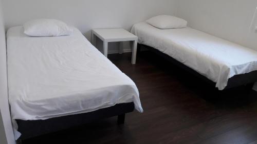 two twin beds in a room with a table at Pärnu Lubja Apartments in Pärnu