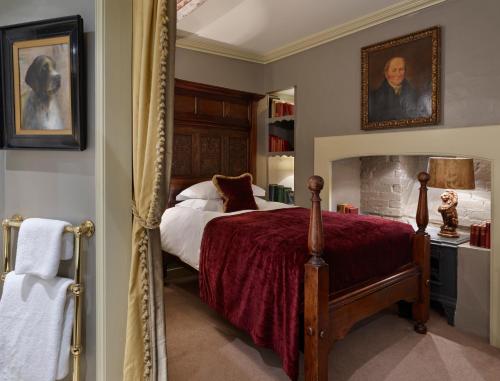 a bedroom with a bed with a red bedspread at Hazlitt's in London