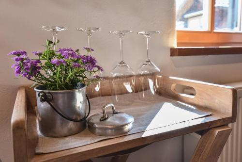 - un évier avec des verres à vin et une théière avec des fleurs violettes dans l'établissement Ferienwohnung Waldblick, à Kleinsteinhausen