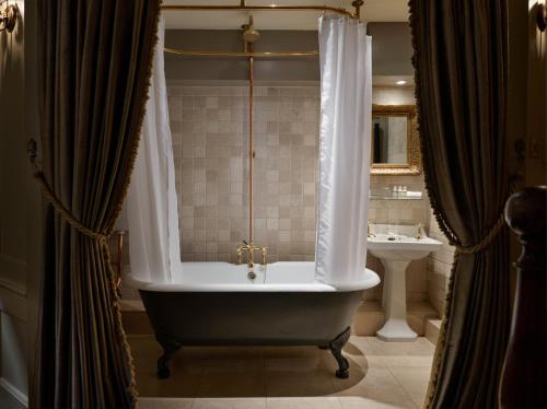 a bathroom with a bath tub and a sink at Hazlitt's in London