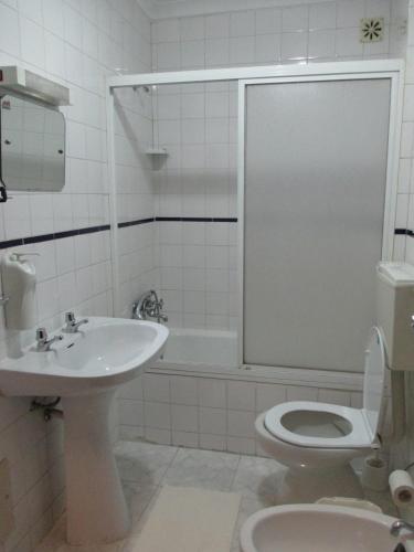 a bathroom with a sink and a toilet and a tub at Guesthouse da Sé in Guarda