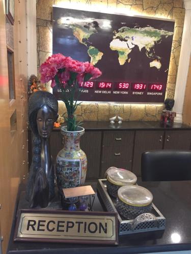 a table with a statue and a vase with flowers at Angel Residency in Greater Noida