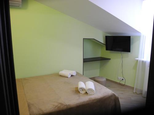 een slaapkamer met een bed met witte schoenen erop bij Cherdachok in Tbilisi City