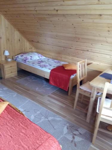 a room with a bed and a table and a chair at Tourist Farm Znidarjevi in Kožljek