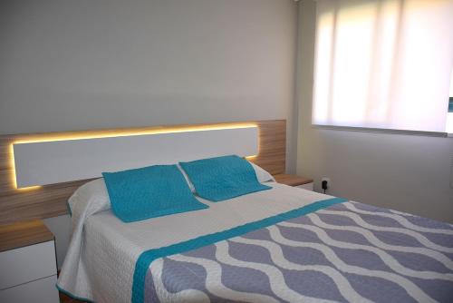 ロス・クリスティアーノスにあるApartamento Cristimarのベッドルーム1室(青い枕2つ付)