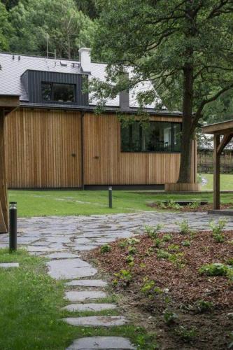 a house with a tree and a stone walkway at Vila Vivenot in Malá Morávka