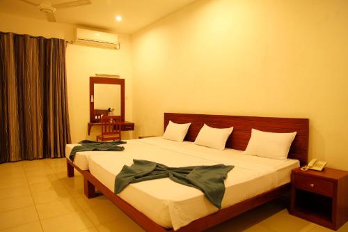 a bedroom with a bed with a bow on it at Aarya hotel in Pinnawala