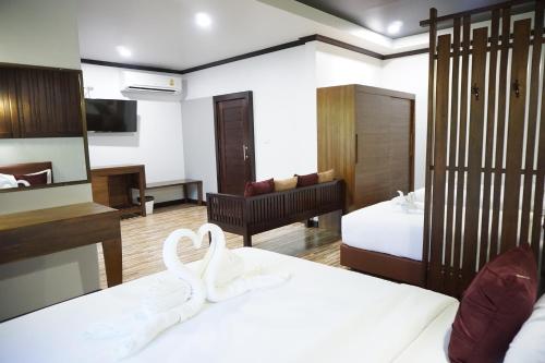 a hotel room with two beds and a living room at Lamai Inn 99 Bungalows in Lamai