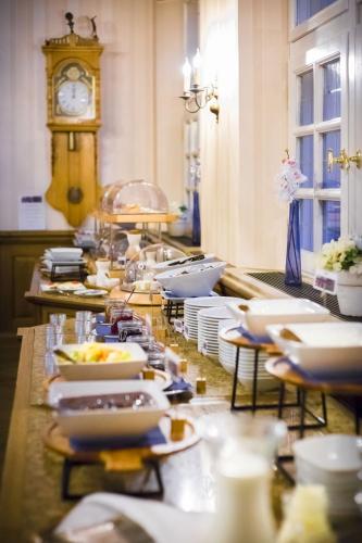 a buffet line with plates of food and a clock at Burghotel Haselünne in Haselünne