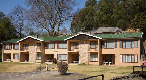 a large building with a green roof at Gooderson Drakensberg Gardens Golf & Spa Resort in Drakensberg Garden