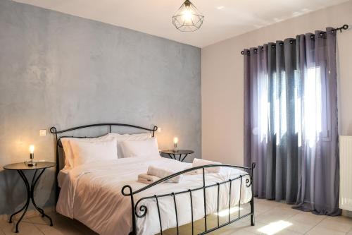 a bedroom with a bed and a gray wall at Meteora View Modern Apartments in Kalabaka