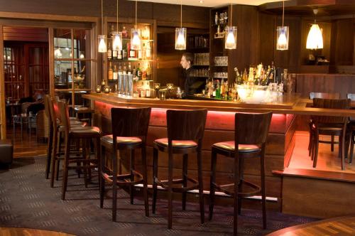 a bar with wooden stools in a restaurant at Sporthotel Leweck in Lipperscheid