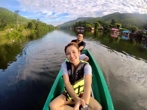 two people are sitting in a boat on a river at Baan Krupong in Ban Tha Thong Mon