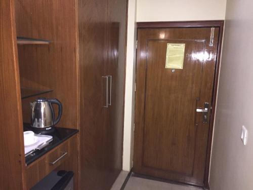 a wooden door in a small room with a kitchen at Angel Residency in Greater Noida