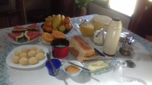 a table topped with plates of food and fruit at Estalagem Engenho de Serra - Parque Nacional do Itatiaia - Parte Alta in Itamonte