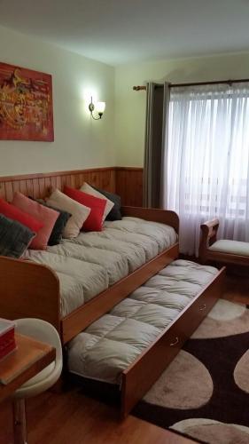 a bed in a room with a window at Depto Parque Suizo 800 in Pucón