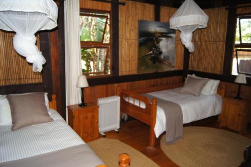 ソドワナ・ベイにあるHouse 23 Ezulwini in Sodwana Bay Lodgeのベッドルーム1室(ベッド2台、窓2つ付)