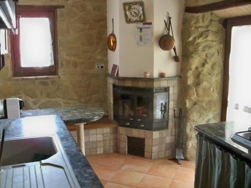 a kitchen with a stone fireplace in a room at IL Casaletto in Subiaco