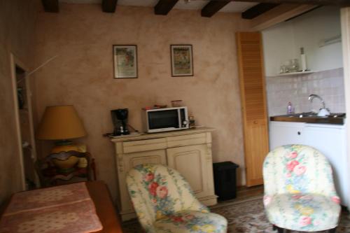 une cuisine avec deux chaises et un four micro-ondes sur un comptoir dans l'établissement Le Loft du Grand Saulaie, à Chambellay